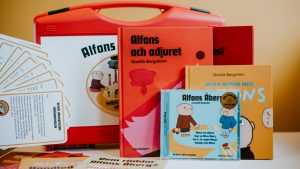 innehållet i en alfonslåda som består av böcker, en cd samt arbetsmaterial