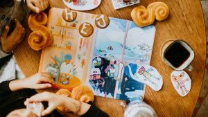 snällkalendern 2019 ligger på ett bord omringad av pepparkakor, lussebullar och kaffe