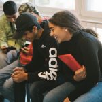 några kompisar skrattar och tittar på en mobiltelefon