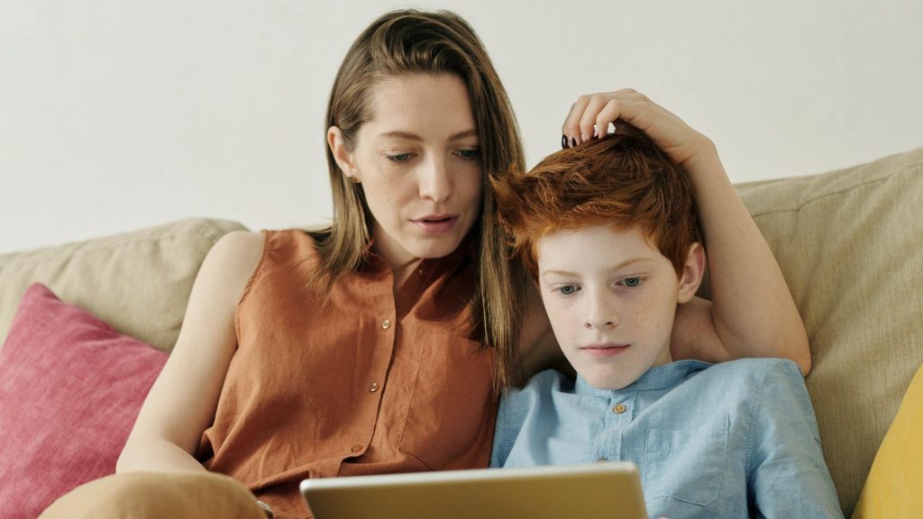 Mamma och barn tittar på en dator