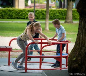 Three kids playing on a carousel