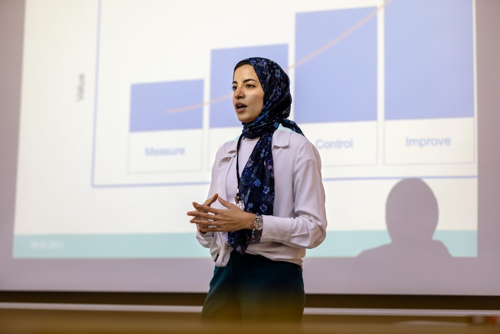 Confident businesswoman giving presentation during seminar.